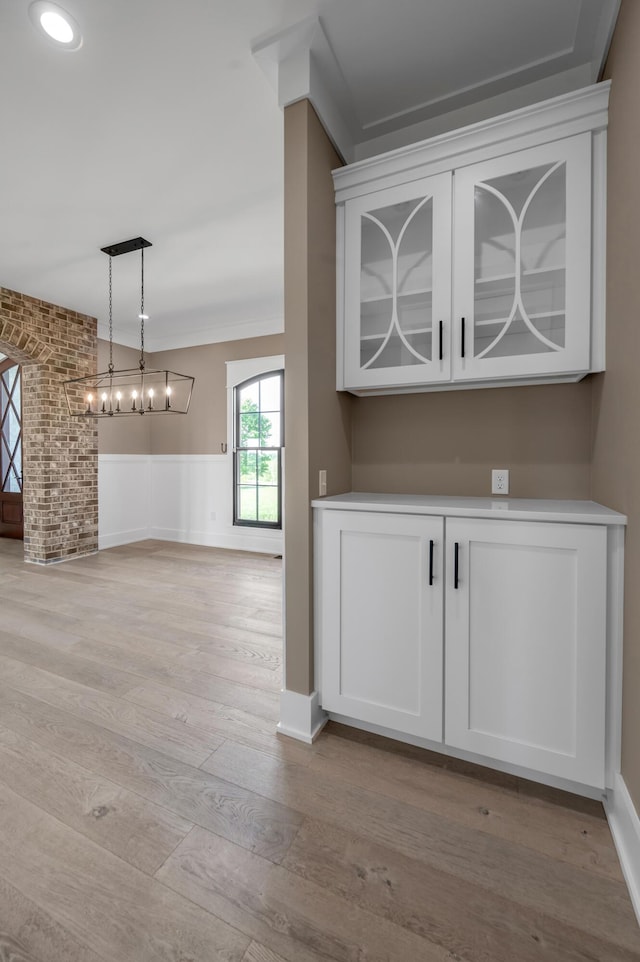 1408 Champion Way, Richmond, KY 40475 - bar area with light wood-style flooring, a wainscoted wall, hanging light fixtures, and a chandelier