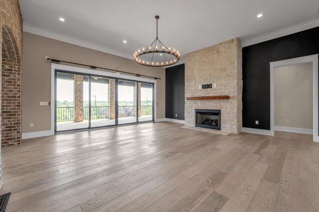 1408 Champion Way, Richmond, KY 40475 - unfurnished living room featuring a chandelier, light wood-style flooring, baseboards, ornamental molding, and a stone fireplace
