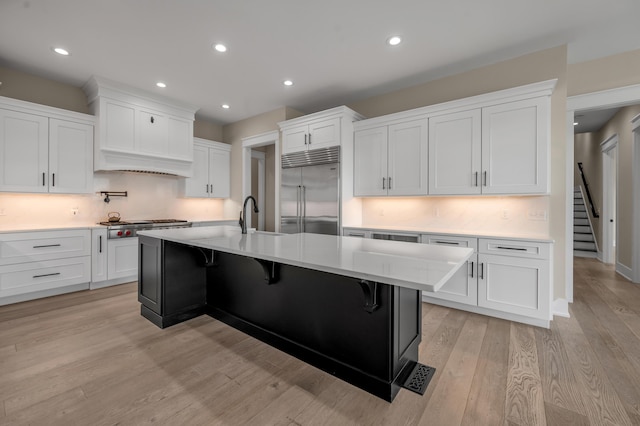 1408 Champion Way, Richmond, KY 40475 - kitchen with stainless steel appliances, light wood finished floors, a sink, light countertops, and white cabinets