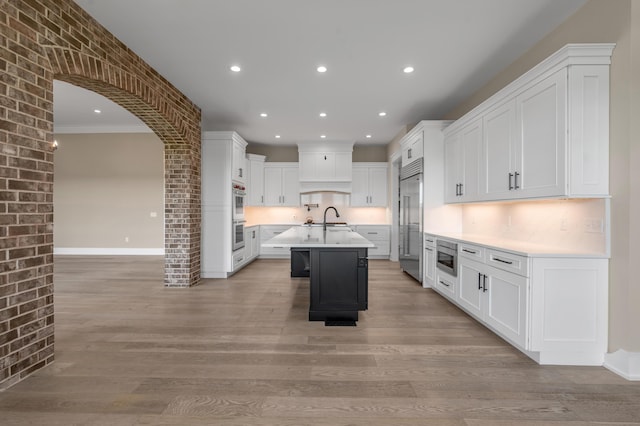 1408 Champion Way, Richmond, KY 40475 - kitchen featuring built in appliances, light countertops, an island with sink, recessed lighting, and light wood-style floors
