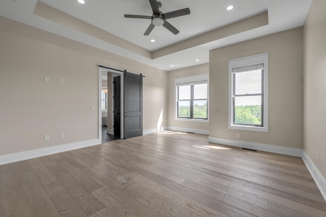 1408 Champion Way, Richmond, KY 40475 - unfurnished bedroom with a barn door, wood finished floors, baseboards, a tray ceiling, and recessed lighting