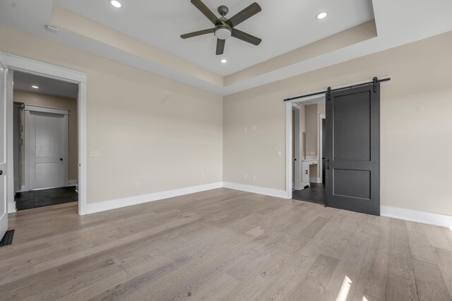 1408 Champion Way, Richmond, KY 40475 - spare room with a ceiling fan, a raised ceiling, a barn door, light wood finished floors, and baseboards