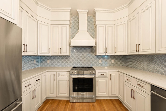406 N Main St, Somerset, KY 42501 - kitchen featuring appliances with stainless steel finishes, premium range hood, light wood-style flooring, and tasteful backsplash