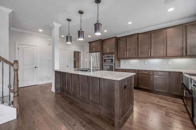 2131 Patchen Lake Ln, Lexington, KY 40505 - kitchen with appliances with stainless steel finishes, crown molding, an island with sink, recessed lighting, and dark brown cabinets