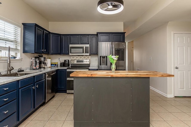186 Santa Barbara Blvd, Georgetown, KY 40324 - kitchen with stainless steel appliances, butcher block countertops, light tile patterned floors, blue cabinetry, and a sink