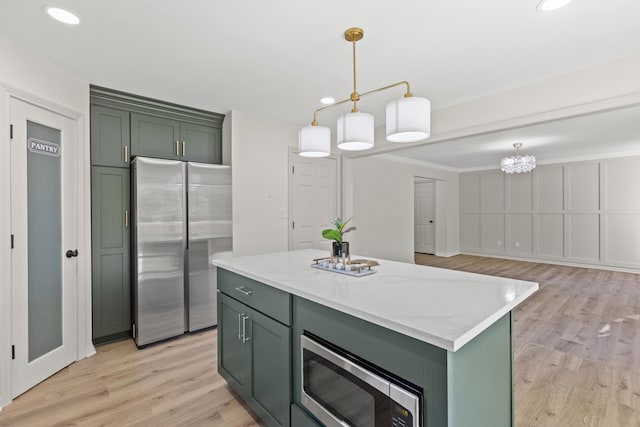3261 Royal Troon Rd, Lexington, KY 40509 - kitchen featuring stainless steel appliances, green cabinets, light wood finished floors, recessed lighting, and hanging light fixtures