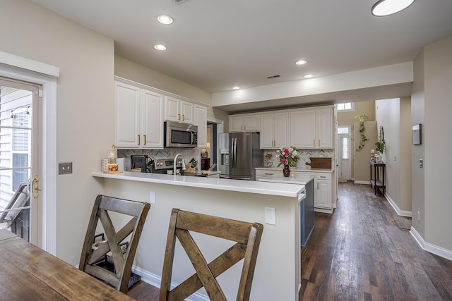 3789 Ridge View Way, Lexington, KY 40509 - kitchen featuring appliances with stainless steel finishes, a peninsula, tasteful backsplash, light countertops, and white cabinetry