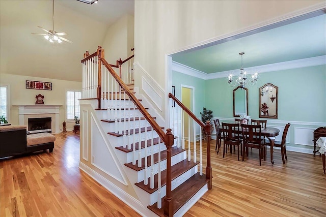 428 Shady Brook Dr, Richmond, KY 40475 - stairs featuring wood finished floors, ceiling fan, high vaulted ceiling, a chandelier, and a high end fireplace