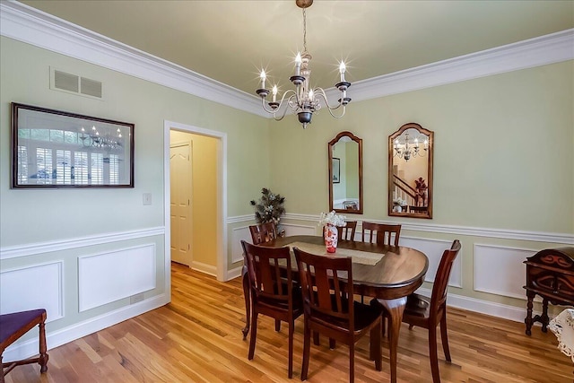 428 Shady Brook Dr, Richmond, KY 40475 - dining area featuring a chandelier, ornamental molding, light wood-style flooring, a decorative wall, and a wainscoted wall