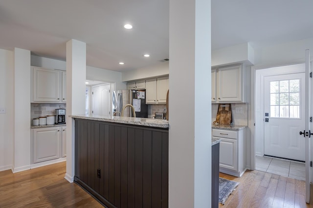 3657 Gladman Way, Lexington, KY 40503 - kitchen featuring stainless steel refrigerator with ice dispenser, light wood finished floors, decorative backsplash, light stone counters, and recessed lighting
