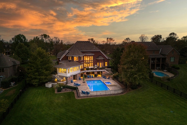 106 Cambridge Ln, Nicholasville, KY 40356 - back of house at dusk featuring a balcony, a patio area, and a jacuzzi