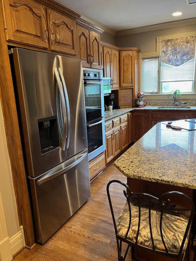 1740 Gose Pike, Danville, KY 40422 - kitchen with appliances with stainless steel finishes, a sink, light stone counters, light wood finished floors, and crown molding