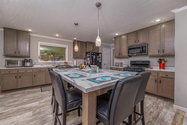 233 Bearskin Holw, Morehead, KY 40351 - kitchen with stainless steel microwave, range with gas stovetop, black fridge, a breakfast bar, and a center island