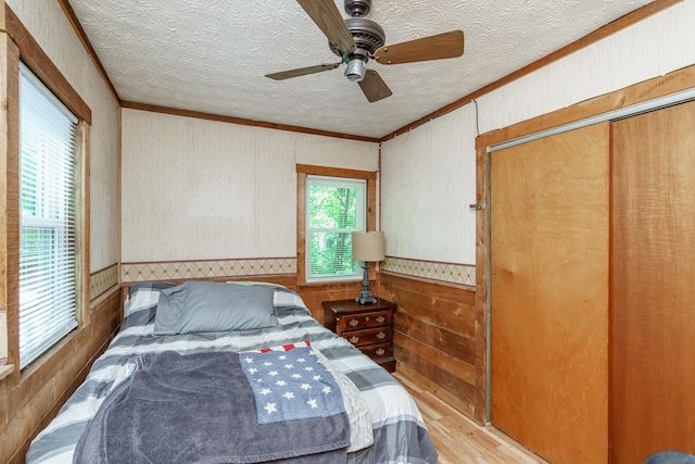 274 Oster Dr, Harrodsburg, KY 40330 - bedroom with ornamental molding, wood finished floors, wood walls, a textured ceiling, and ceiling fan
