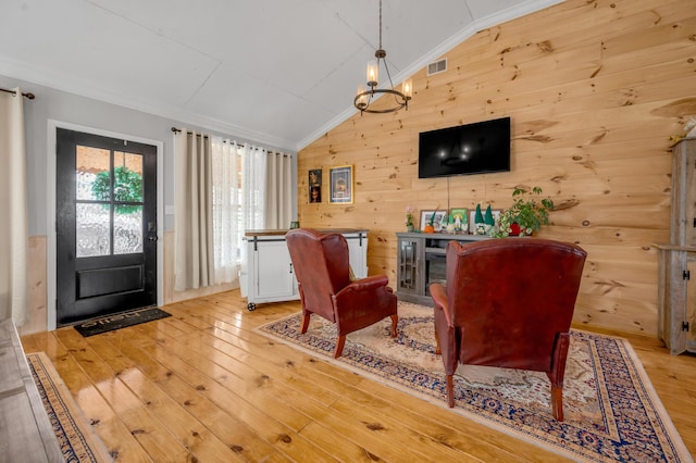 1235 Jackstown Rd, Paris, KY 40361 - living room featuring light wood-style flooring, vaulted ceiling, ornamental molding, wooden walls, and a chandelier
