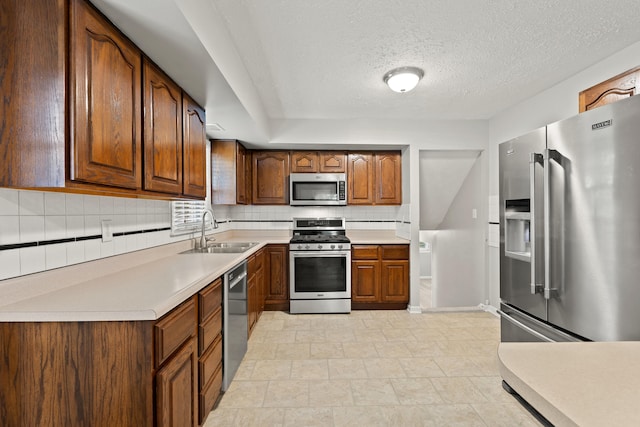 2371 Pierson Dr, Lexington, KY 40505 - kitchen featuring stainless steel appliances, a sink, backsplash, light countertops, and a textured ceiling
