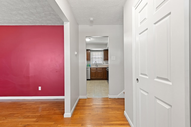 2371 Pierson Dr, Lexington, KY 40505 - hallway with a textured ceiling, light wood-style flooring, baseboards, and a sink