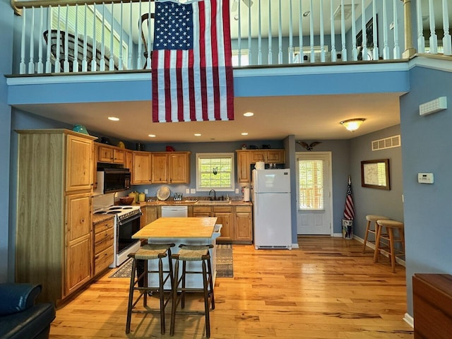 169 Kennedy Ln, Lancaster, KY 40444 - kitchen with white appliances, light wood-style flooring, a high ceiling, baseboards, and recessed lighting