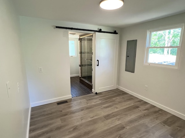 819 Scotts Chapel Rd, Jamestown, KY 42629 - unfurnished bedroom with electric panel, a barn door, wood finished floors, baseboards, and connected bathroom