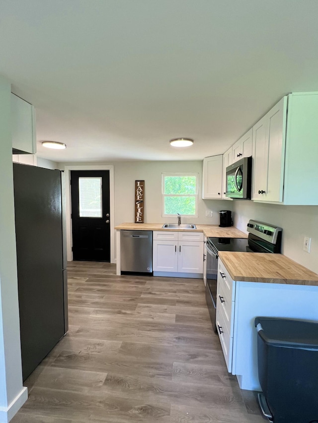 819 Scotts Chapel Rd, Jamestown, KY 42629 - kitchen featuring appliances with stainless steel finishes, a sink, wooden counters, white cabinets, and light wood finished floors