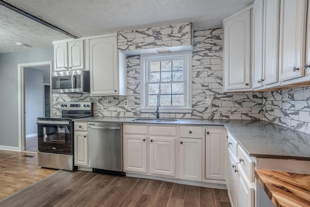 108 Rancho Ct, Frankfort, KY 40601 - kitchen featuring stainless steel appliances, a sink, a textured ceiling, dark wood-type flooring, and white cabinetry