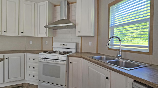 2499 Sacker Rd, Manchester, KY 40962 - kitchen with white gas stove, wall chimney exhaust hood, a sink, white cabinets, and tasteful backsplash