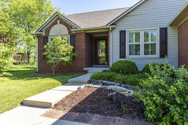 4140 Clearwater Way, Lexington, KY 40515 - view of exterior entry with a yard, a shingled roof, and brick siding