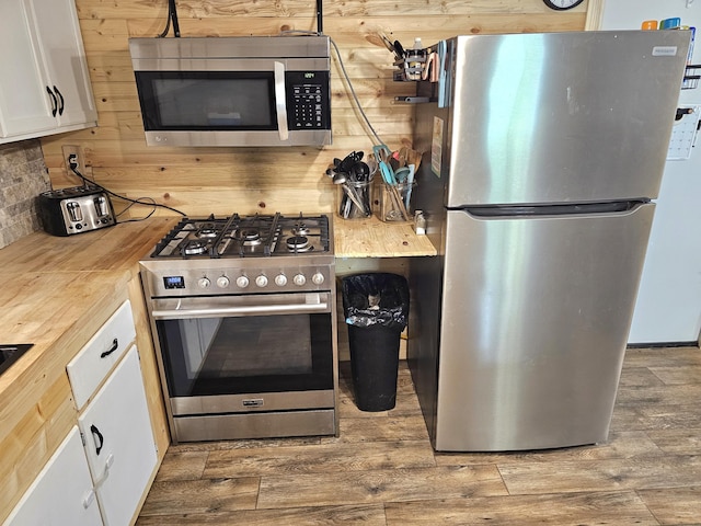 270 Newcomb Ave, Mount Vernon, KY 40456 - kitchen featuring appliances with stainless steel finishes, white cabinets, wood finished floors, butcher block countertops, and wood walls