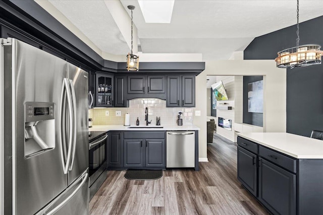 253 Gateway Park Cir, Lexington, KY 40511 - kitchen featuring appliances with stainless steel finishes, a sink, a chandelier, a skylight, and dark wood-type flooring
