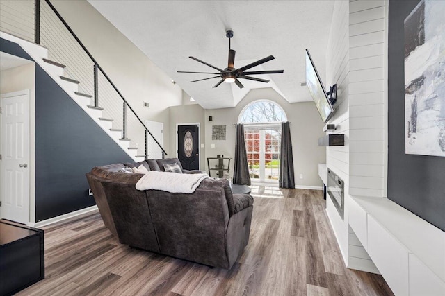 253 Gateway Park Cir, Lexington, KY 40511 - living area featuring a ceiling fan, wood finished floors, a large fireplace, high vaulted ceiling, and stairway