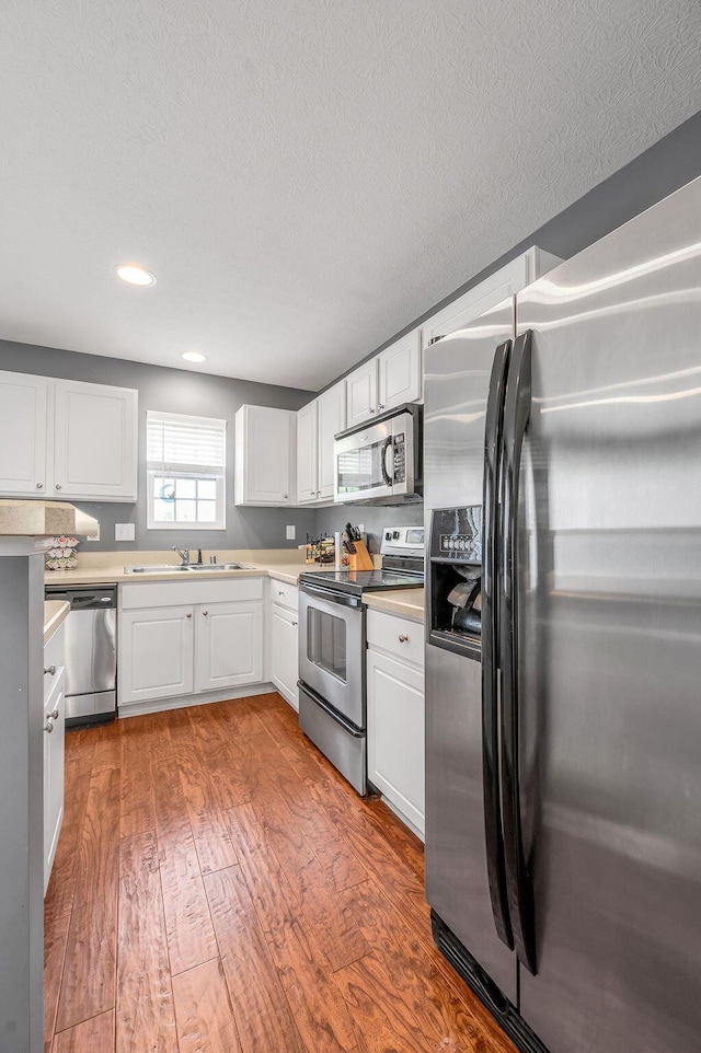 2433 Aristocracy Cir, Lexington, KY 40509 - kitchen with appliances with stainless steel finishes, wood-type flooring, white cabinets, light countertops, and a sink