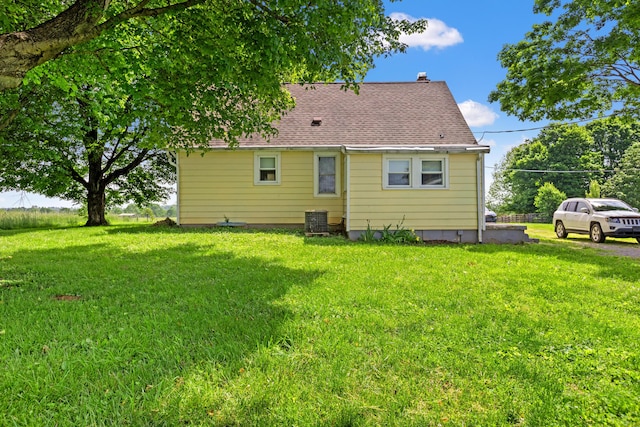 10165 Clifton Rd, Versailles, KY 40383 - rear view of property featuring a lawn, a chimney, central AC unit, and roof with shingles