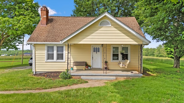 10165 Clifton Rd, Versailles, KY 40383 - bungalow-style home with a shingled roof, a chimney, a front lawn, and covered porch