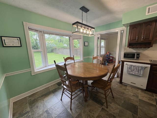 524 Cromwell Way, Lexington, KY 40503 - dining space with stone tile flooring, baseboards, and a textured ceiling