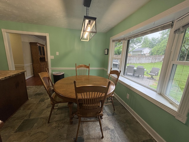 524 Cromwell Way, Lexington, KY 40503 - dining room with stone tile flooring, baseboards, a textured ceiling, and a wainscoted wall