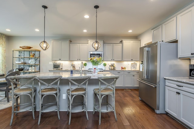 320 Manitoba Ln, Lexington, KY 40515 - kitchen with high quality fridge, light stone counters, decorative backsplash, a center island with sink, and recessed lighting