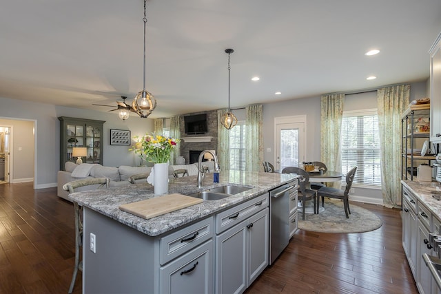 320 Manitoba Ln, Lexington, KY 40515 - kitchen featuring a sink, dishwasher, open floor plan, a large fireplace, and dark wood-type flooring