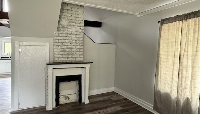 606 Prospect St, Berea, KY 40403 - unfurnished living room with dark wood-style flooring, a sink, a textured ceiling, a fireplace, and lofted ceiling