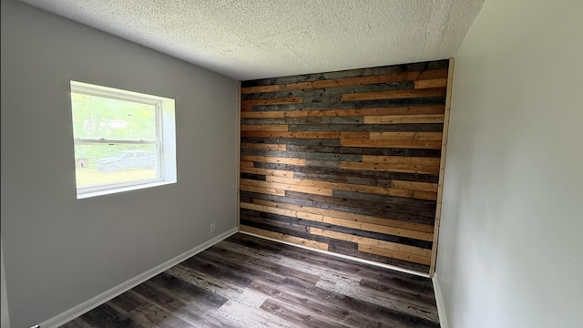 606 Prospect St, Berea, KY 40403 - spare room featuring a textured ceiling, dark wood-style floors, baseboards, and wood walls