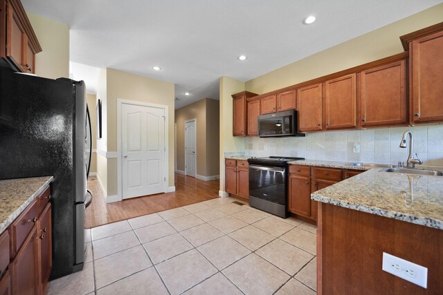 262 Silver Creek Dr, Somerset, KY 42503 - kitchen featuring electric range, freestanding refrigerator, a sink, brown cabinets, and recessed lighting