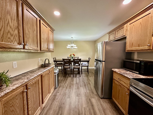110 Witt Rd, London, KY 40741 - kitchen with appliances with stainless steel finishes, wood finished floors, brown cabinets, a chandelier, and recessed lighting