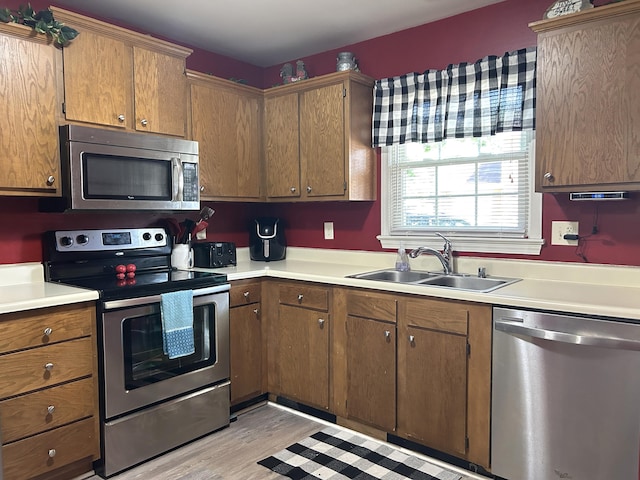 1352 Deer Lake Cir, Lexington, KY 40515 - kitchen featuring appliances with stainless steel finishes, a sink, light countertops, light wood-type flooring, and brown cabinets