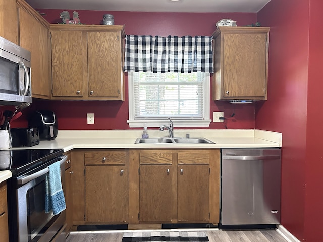 1352 Deer Lake Cir, Lexington, KY 40515 - kitchen featuring stainless steel appliances, a sink, light countertops, light wood finished floors, and brown cabinetry