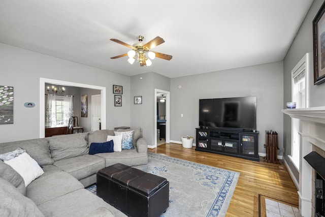 164 River Run Dr, Lancaster, KY 40444 - living area with wood finished floors, a fireplace with flush hearth, ceiling fan, and a chandelier