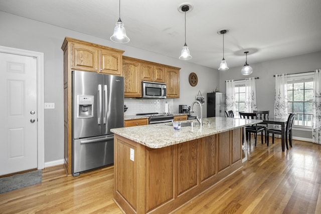 164 River Run Dr, Lancaster, KY 40444 - kitchen with appliances with stainless steel finishes, light wood-style flooring, a sink, backsplash, and light stone countertops