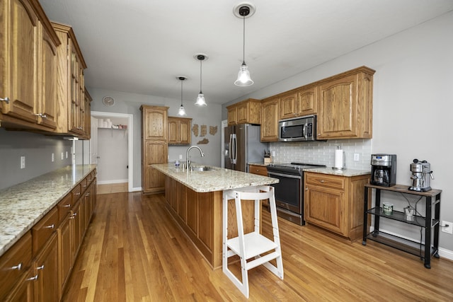 164 River Run Dr, Lancaster, KY 40444 - kitchen with stainless steel appliances, backsplash, light wood-style floors, brown cabinets, and a kitchen bar