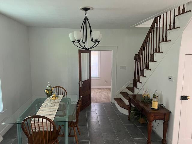 505 Burkesville St, Columbia, KY 42728 - dining space featuring stairs, a chandelier, baseboards, and dark tile patterned flooring
