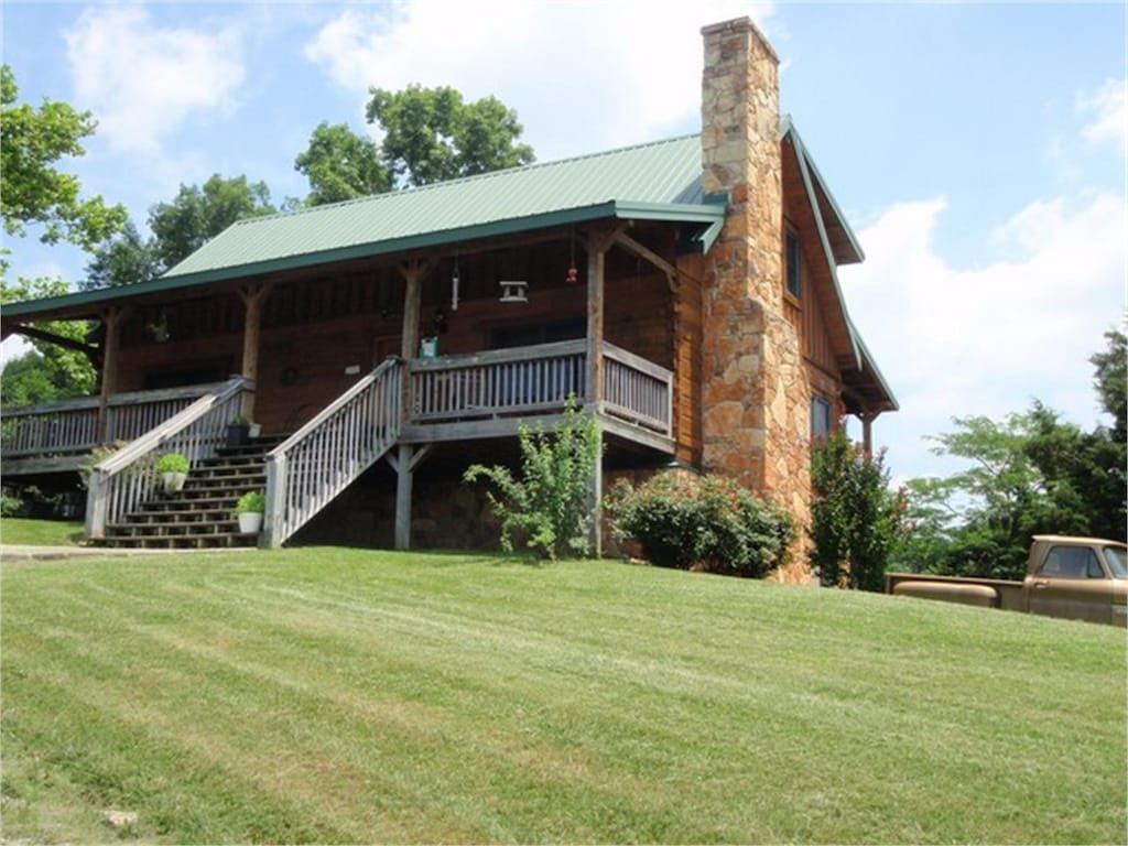 5080 Dry Branch Rd, Lexington, KY 40515 - view of front facade with a chimney, a front yard, a porch, metal roof, and stairway