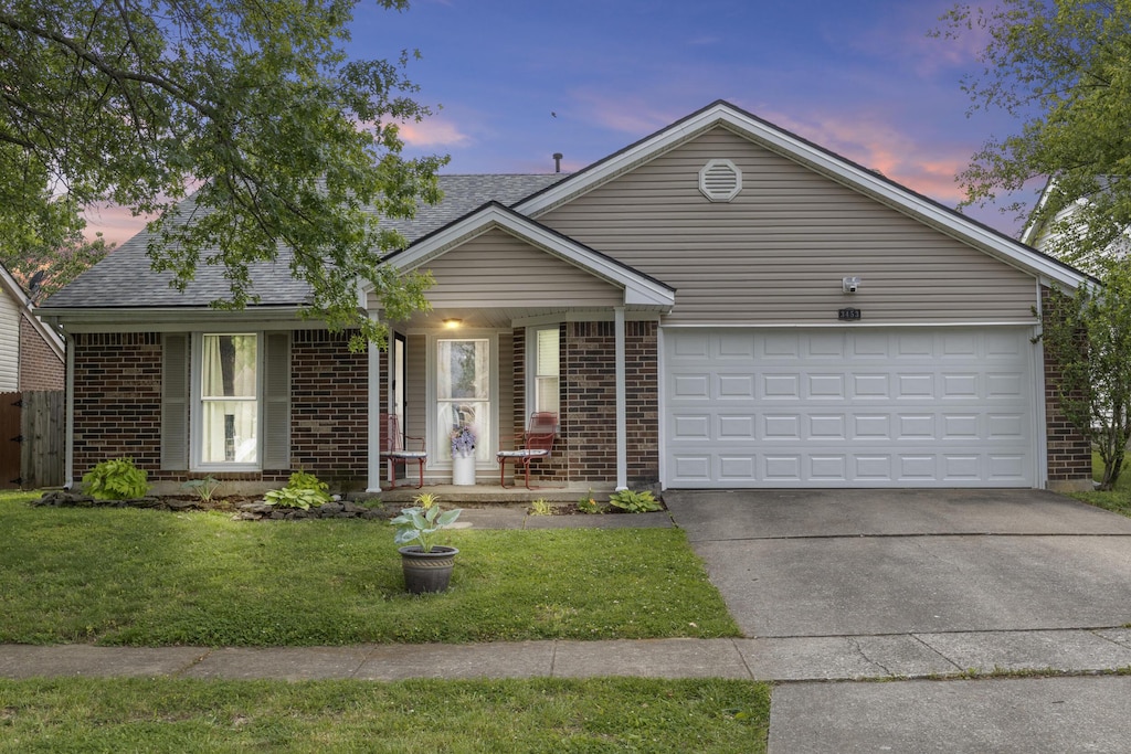 3453 Colonnade Dr, Lexington, KY 40515 - single story home featuring brick siding, driveway, a yard, an attached garage, and roof with shingles