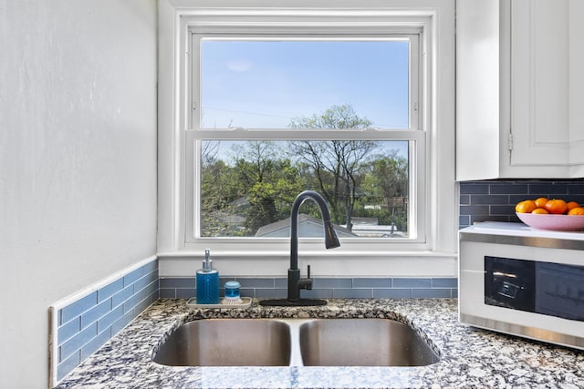 112 Gano Ave, Georgetown, KY 40324 - kitchen view of a sink, stone countertops, decorative backsplash, and white cabinets